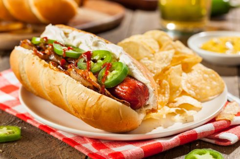 seattle style hot dog with cream cheese, jalapeños, grilled onions and sriracha