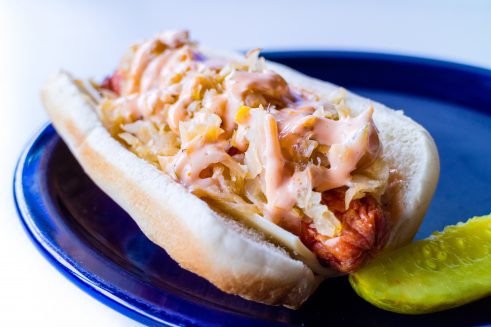 kansas city style hot dog like a reuben sandwich with sauerkraut, thousand island or mustard and melted swiss cheese on a sesame seed bun